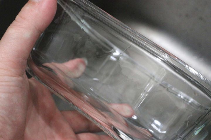 洗い終わって透明になったガラス容器を手に持ち確認している様子