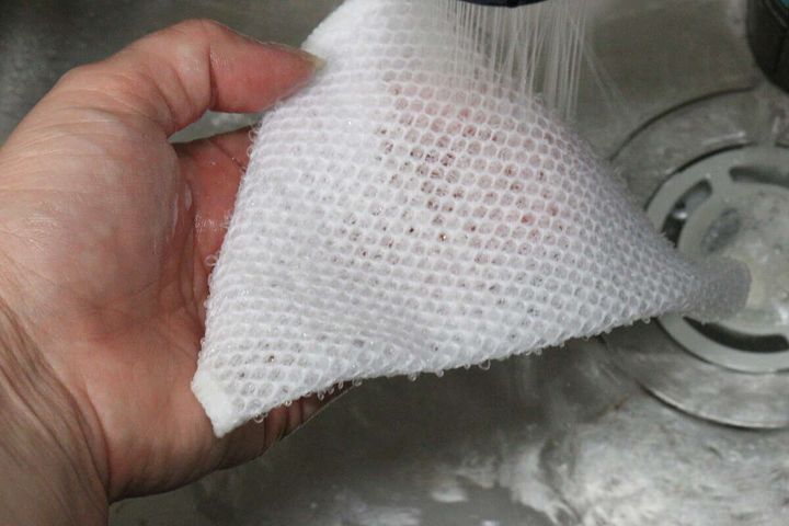 水道の水でメッシュクロスをすすいでいる手元、水切れの良さがわかる