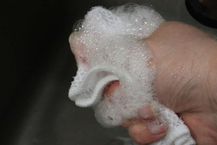 手の中でメッシュクロスが洗剤で泡立っている様子