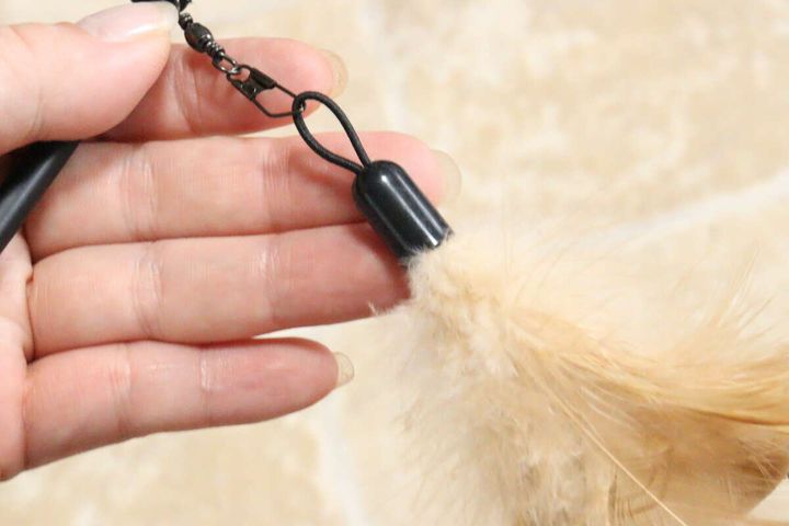 ねこじゃらしの羽と金具の接続部分を指でつまんでいるアップ