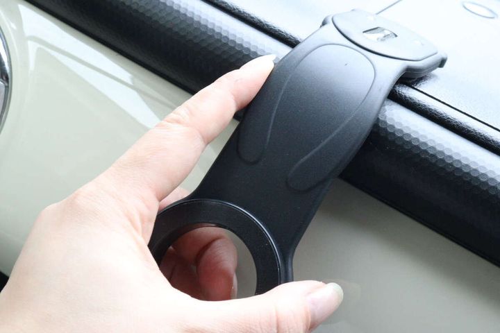 女性がスマホスタンドを車のダッシュボードに合わせて曲げている