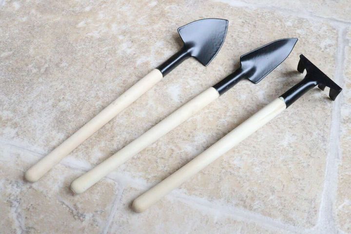 木柄のスコップ2本とレーキが並べられた俯瞰