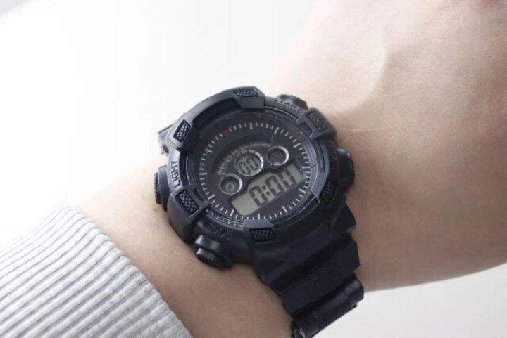左腕に装着された黒いデジタルウォッチ。時刻は0時0分を表示している。