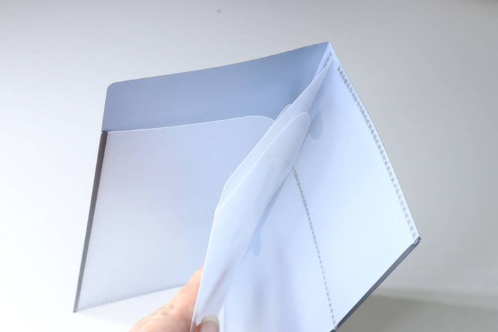 女性がチケットファイルを開き、内側の透明ポケットを見せている