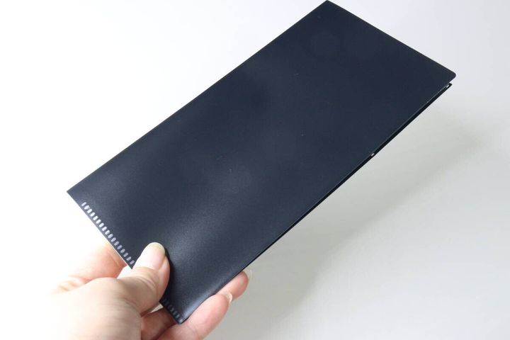 女性が手に持った黒いチケットファイルを閉じた状態