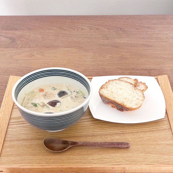 MISOVATIONの牛乳アレンジスープとパンが木製トレーに置かれている
