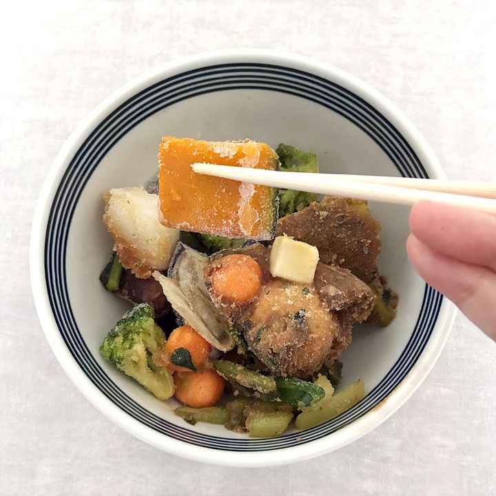 箸で冷凍MISOVATIONの具材（かぼちゃ）を掴んでいる手