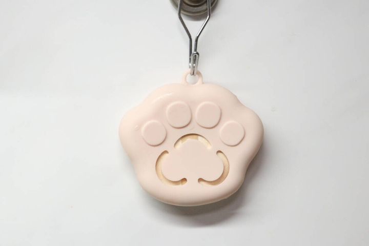 ピンクの肉球型パフケースをフックに引っ掛けて乾燥させている