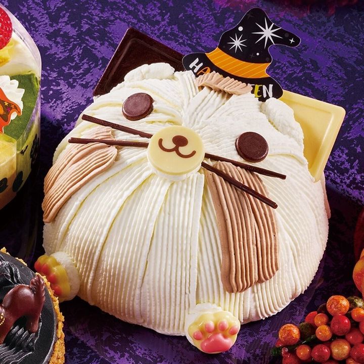 白いクリームでできた魔女の帽子をかぶった猫のデコレーションケーキ