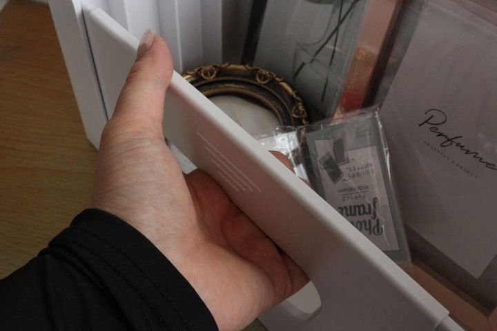 ファイルスタンドの取っ手部分を掴んでいる手元