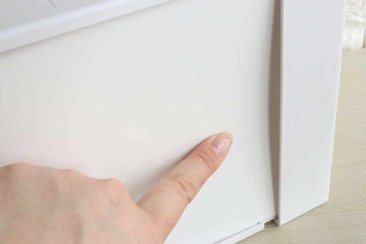 白いファイルスタンドの底面を指で押している様子