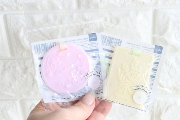 ピンク色の桜柄と黄色のミモザ柄のラバーサシェを両手に持っている様子