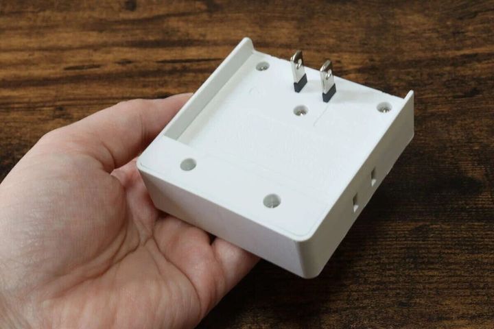 手のひらに乗せたスクエアタップの裏面とプラグ