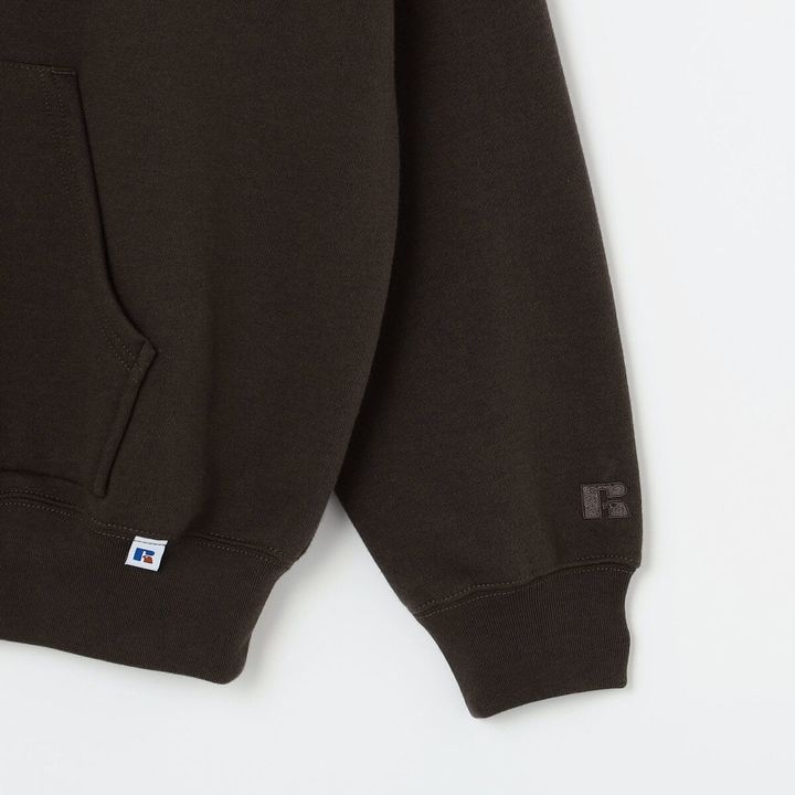 左袖口近くにはRUSSELL ATHLETICのロゴ刺繍を配置。ボディと同色にすることで主張を抑え、モダンな印象に仕上げた。