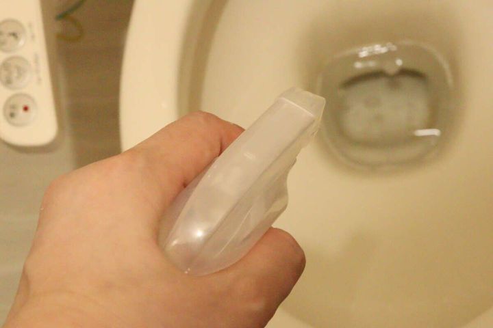 透明なスプレーボトルでトイレの便器内に洗浄液を噴射