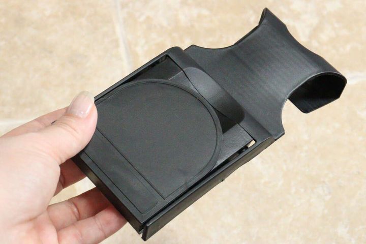 女性の手がダイソーの折りたたみ式車載ドリンクホルダーを持っている