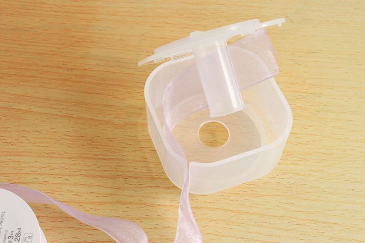 リボンホルダーの柱に薄紫色のリボンを引っ掛けている様子