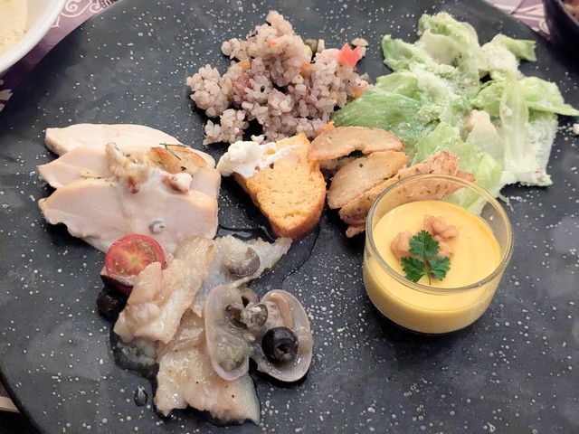 ローストチキンや温野菜サラダ、ライスサラダ、かぼちゃのムースを取り分けたお皿