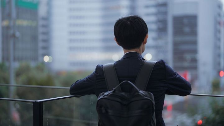 リュックを背負っているスーツ姿の男性