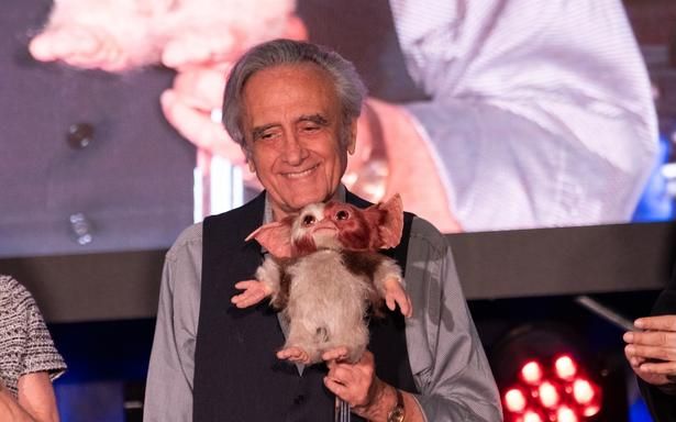 【写真を見る】ギズモの登場に、ニコニコ笑顔のジョー・ダンテ監督