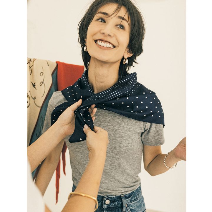 グレーTシャツにドット柄スカーフを巻く神山まりあさん
