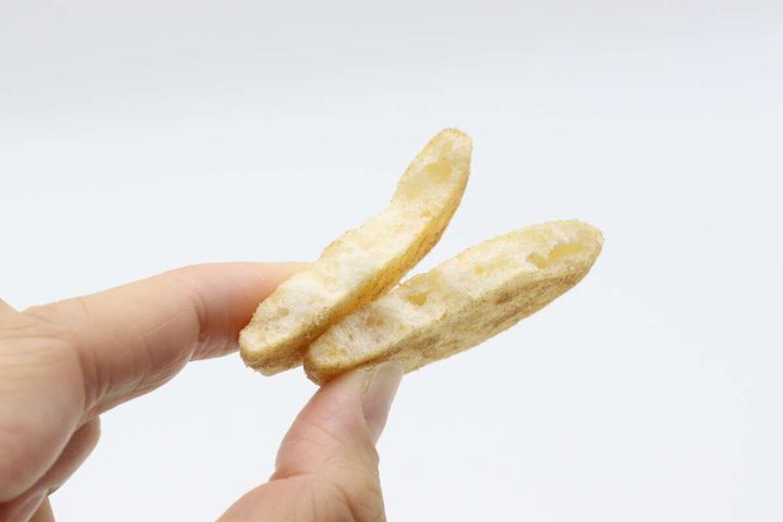 指でつまんだ2枚のファミマ味ソフトせんべい。表面に味付けが見える