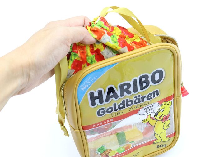 HARIBOポーチの中にゴールドベア柄の巾着を入れている手元