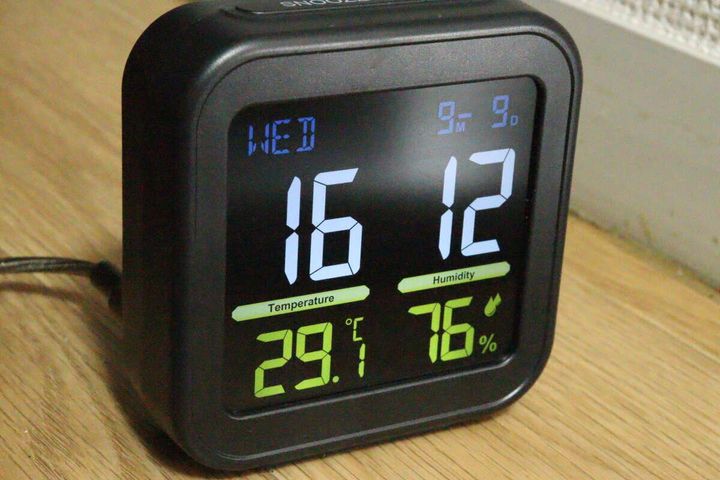 暗い部屋で時刻と温湿度がくっきりと表示されたデジタル時計