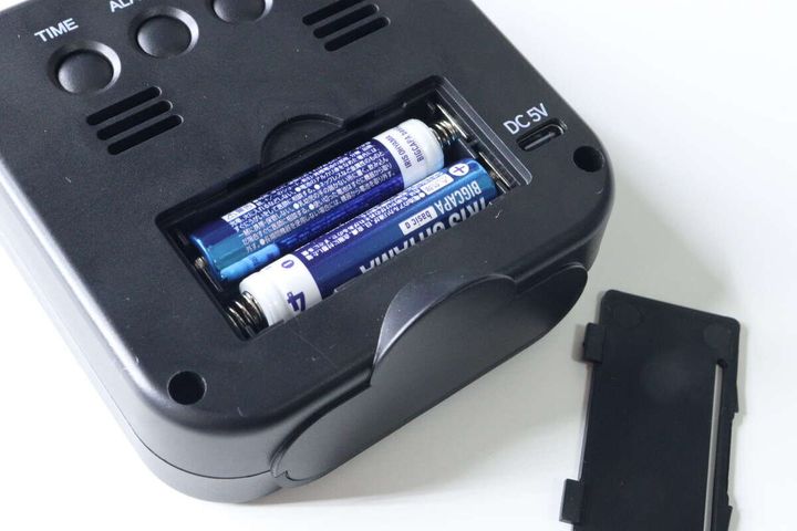 デジタル時計の裏蓋を開け、単4電池が2本入っている様子