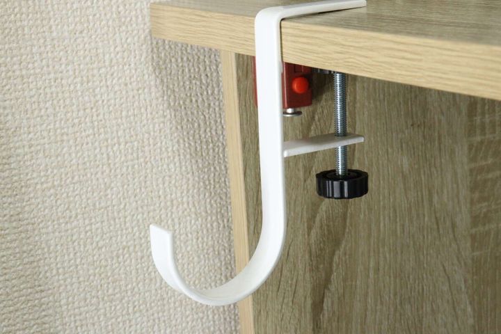 木目調のテーブルの端に白いテーブルフックがしっかりと固定されている