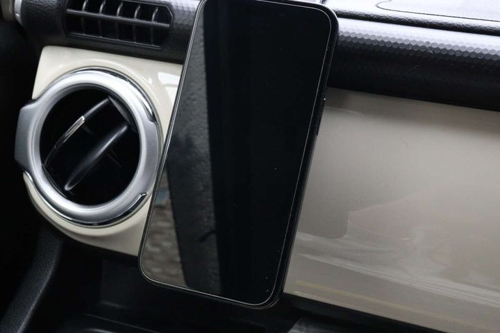 車のダッシュボードに設置された車載ホルダーにスマートフォンが固定されている