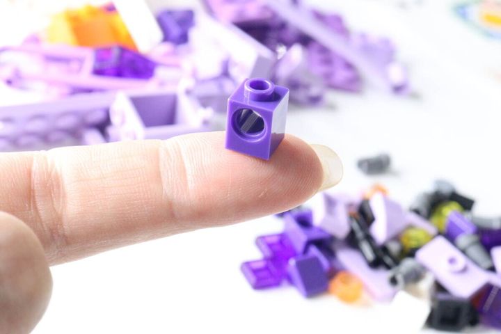 人差し指の先に乗せられた小さな紫色のブロック
