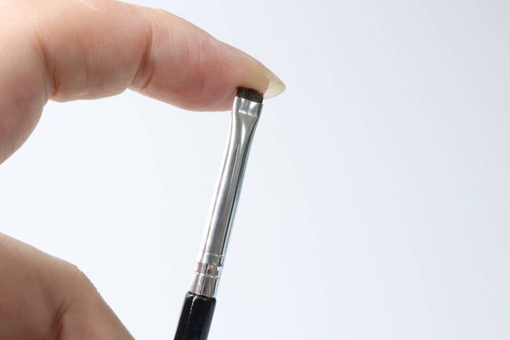 指でアイライナーブラシの毛先をつまんでいる様子