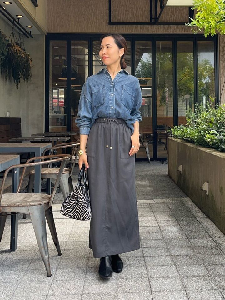 デニムシャツをインしてグレーのナロースカートを穿いた女性の全身