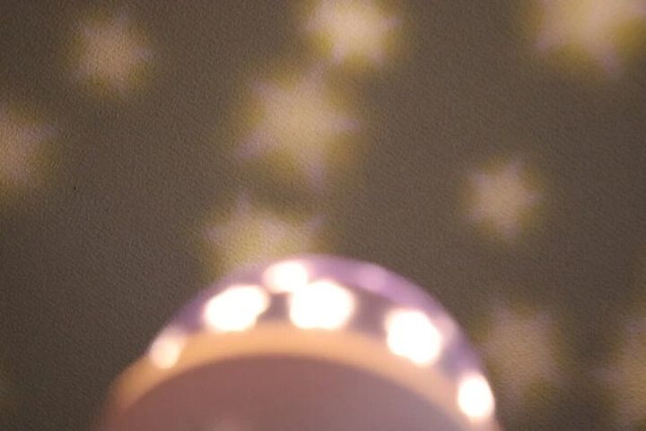 プラネタリウムライトが壁に星の模様を映し出している様子