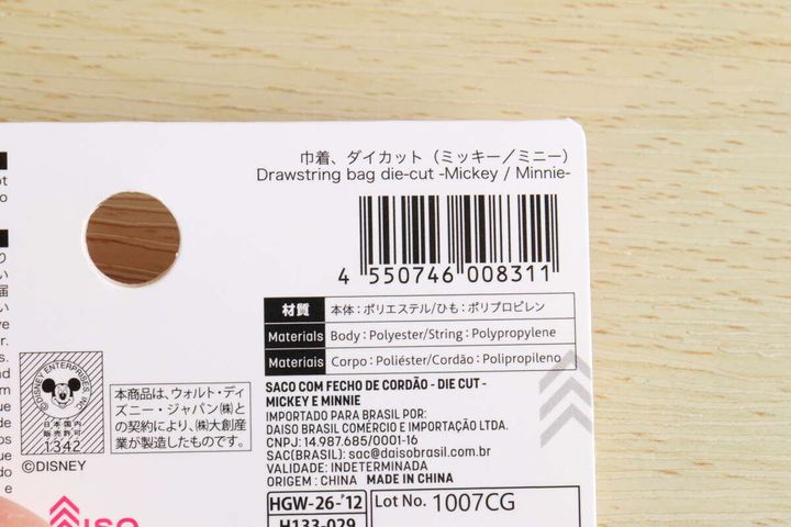 巾着袋の商品タグの裏面アップ。バーコードや商品名、材質、製造元などの情報が詳細に記載されている。