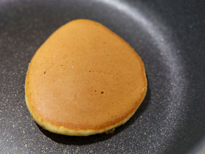 きつね色に焼き色がつき、裏返されたどら焼き生地