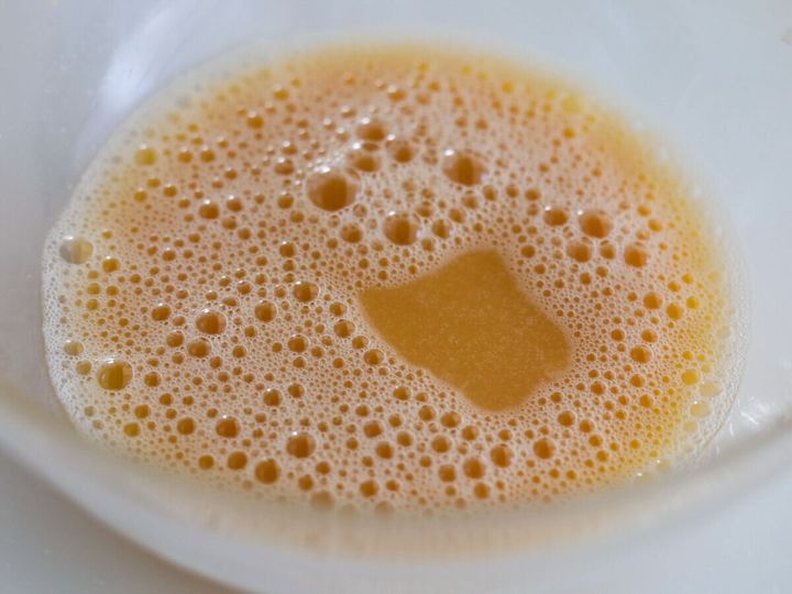 ボウルに入った卵、砂糖、はちみつ、みりん、水を混ぜた泡立った液体
