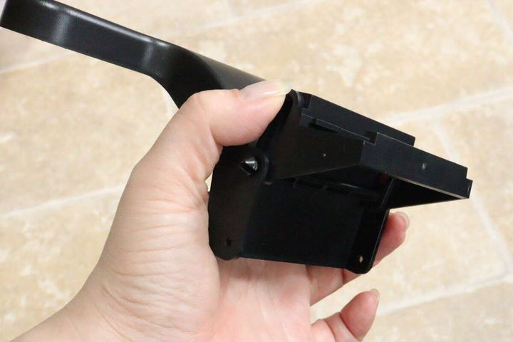 女性の手が車用トレイのアーム裏側のスライダー部分を指している