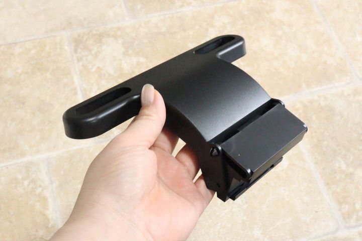 女性の手が黒い車用トレイのアーム部分を横から持っている