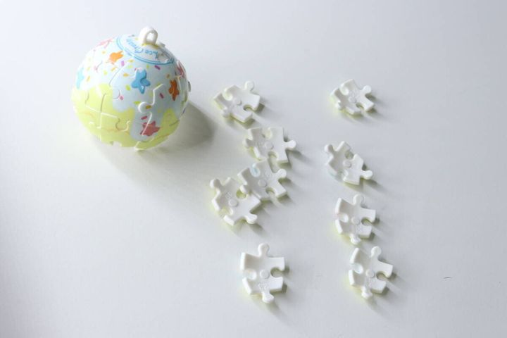 完成した球体パズルと、まだ組み立てていない白いパズルピースが数個置かれている。