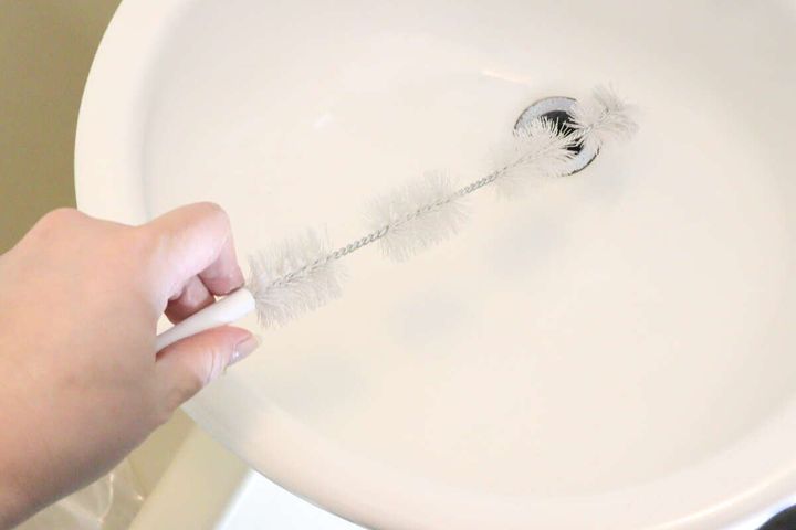 女性が洗面台の排水口に4連パイプクリーナーを差し込んでいる