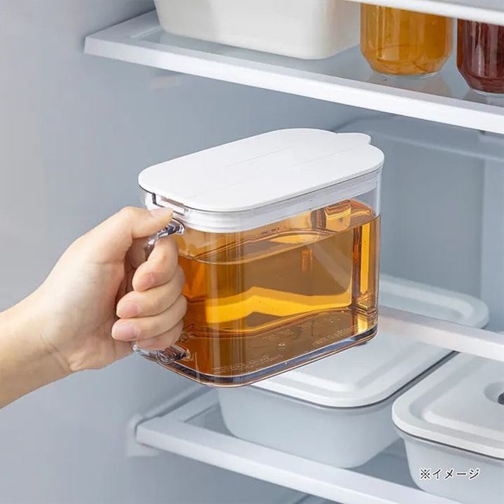 冷蔵庫の棚から片手でコンパクトな冷水筒を取り出す手元