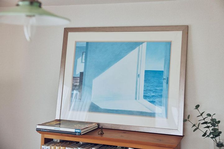 本棚の上の絵画は、エドワード・ホッパーの「海辺の部屋」のレプリカ。「江國香織さん作の『日のあたる白い壁』にこの絵が掲載されているのですが、そこに添えられていた文章がすてきで。影響を受けて、この絵を買ってしまいました」
