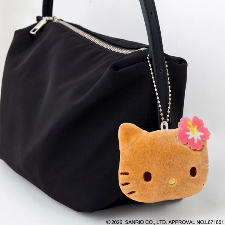 黒いバッグにハローキティの顔型カップスリーブチャームがぶら下がっている