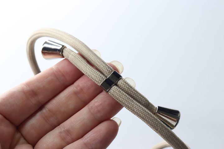指でストラップの長さ調整金具を触っている様子