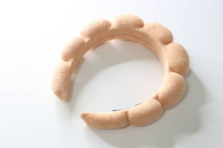白い背景に置かれたベージュのもこもこカチューシャ