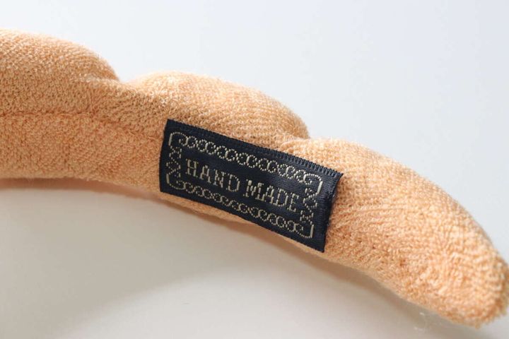 カチューシャに縫い付けられた「HAND MADE」と書かれた黒いタグ