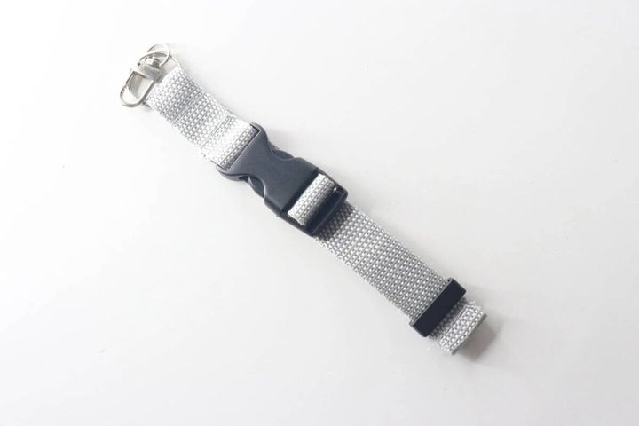 グレーのベルトキーホルダーが白い背景に置かれている