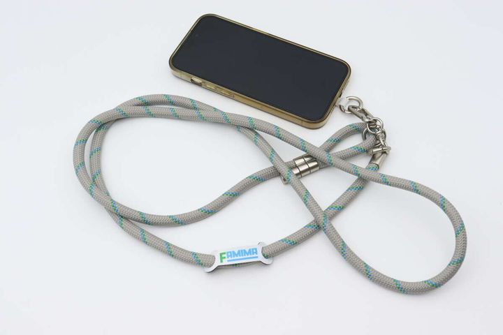 スマートフォンに装着されたグレーのスマホストラップ全体